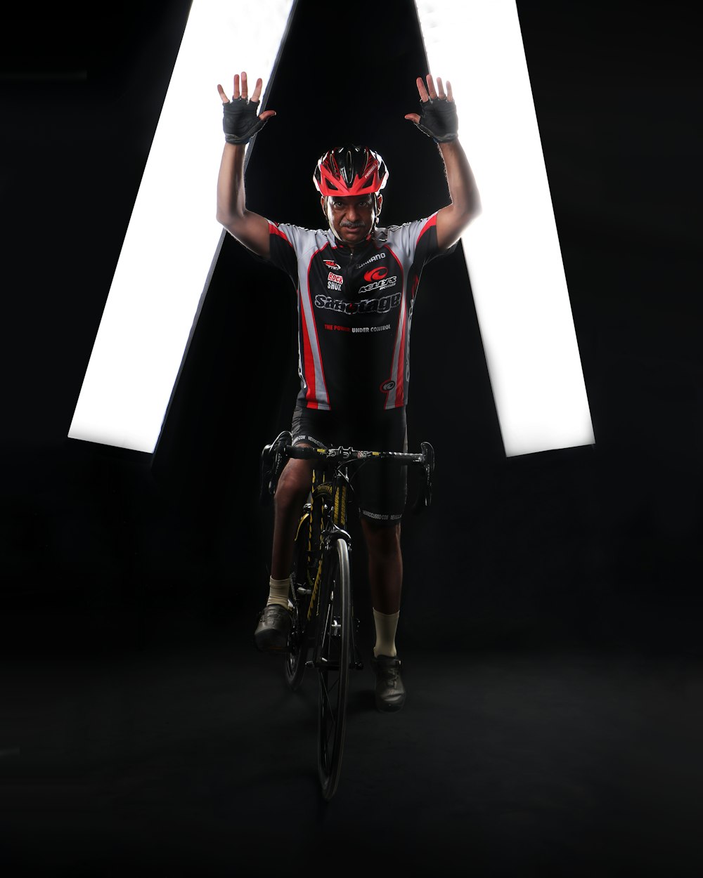 a man riding a bike in front of a large letter