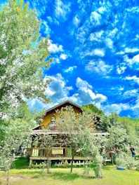 A cozy house surrounded by a green garden under clear blue sky.