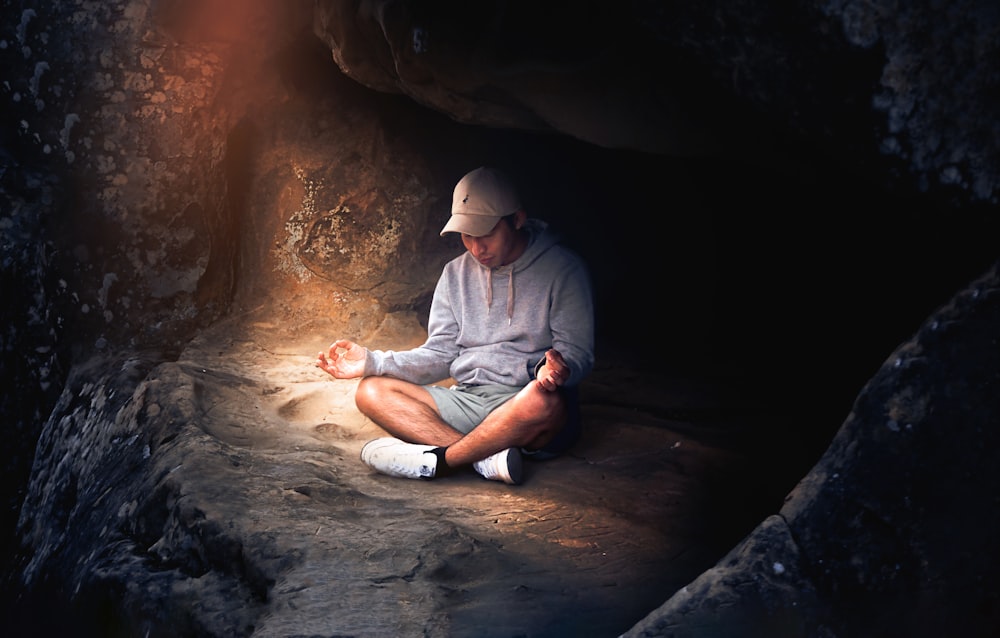 a man sitting on the ground in a cave