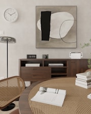 a picture of a table with books and a clock on the wall