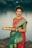 a woman in a red and green sari holding a plate of food