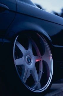 Technical shot of a BMW air suspension component with subtle blue lighting reflecting off the metallic surface.