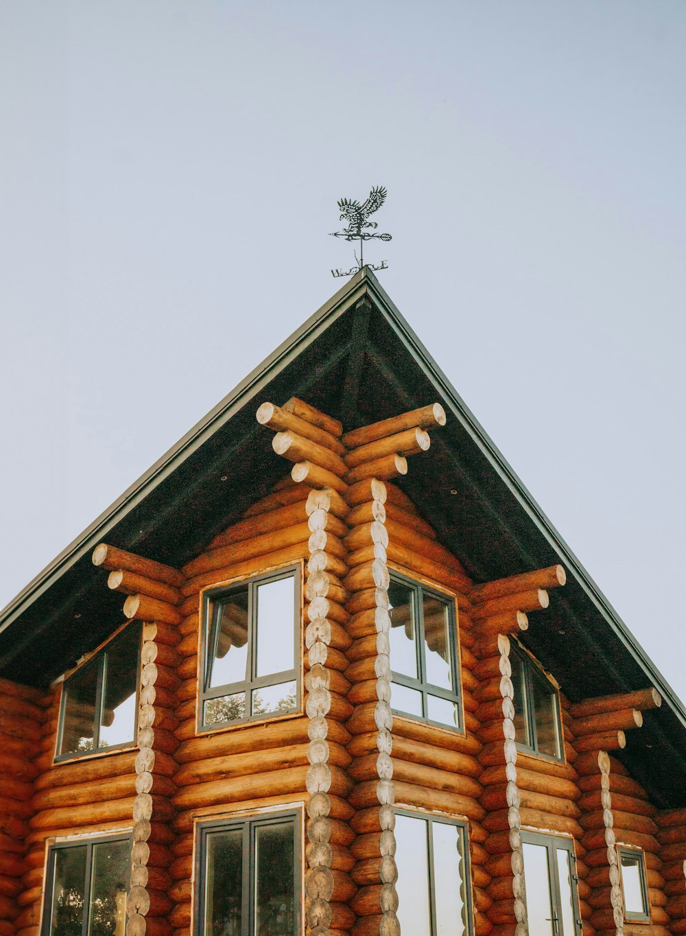 a log house with a weather vane on top of it