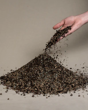 A close-up of hands mixing natural soil materials for eco-friendly pavement.