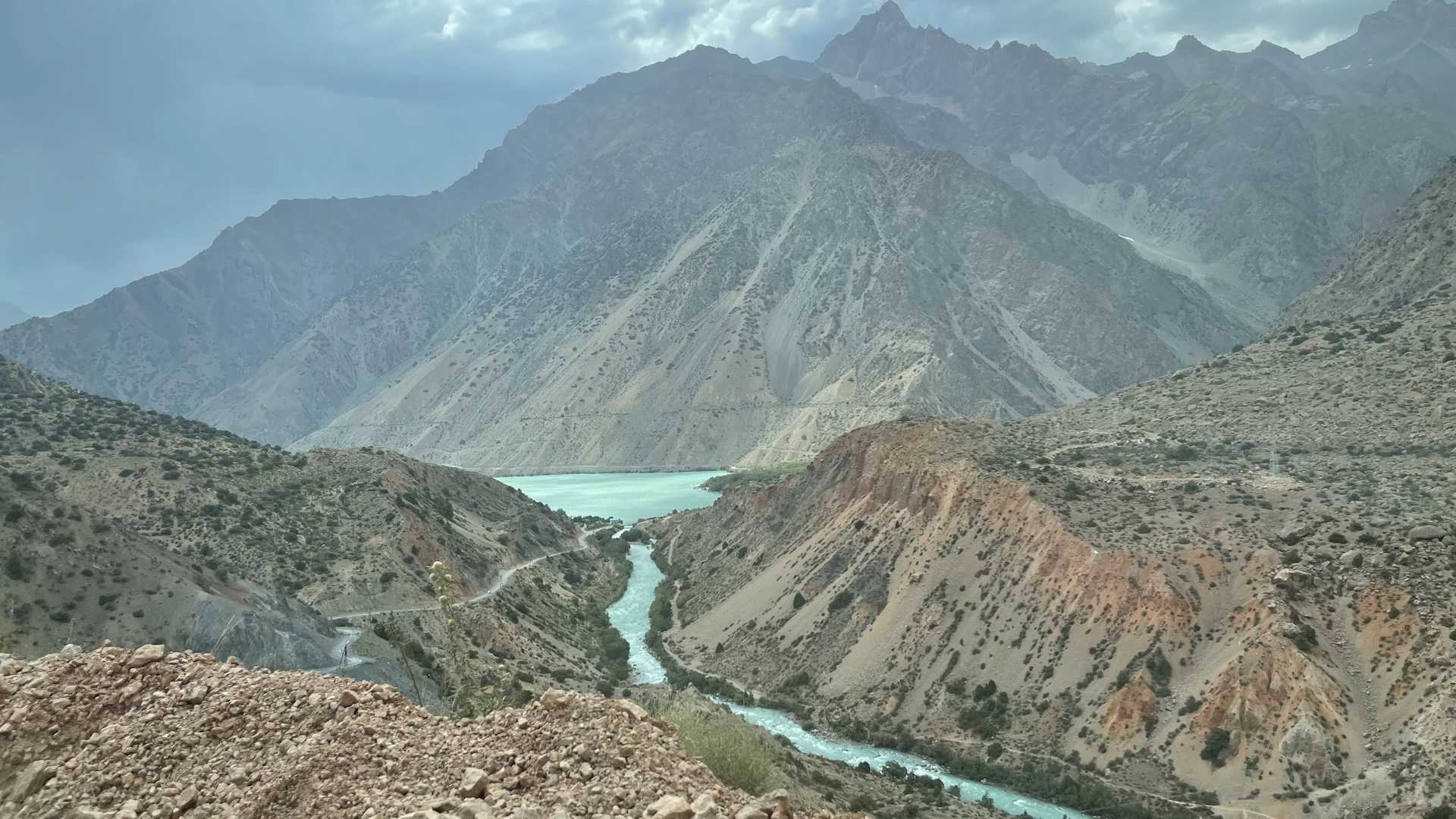 a view of a river and mountains from the top of a hill