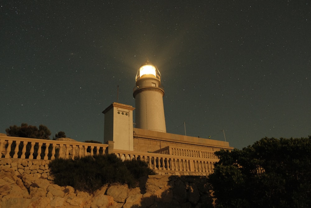 Un faro en la cima de un acantilado bajo un cielo nocturno