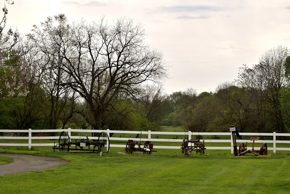 a white fence in the middle of a grassy field