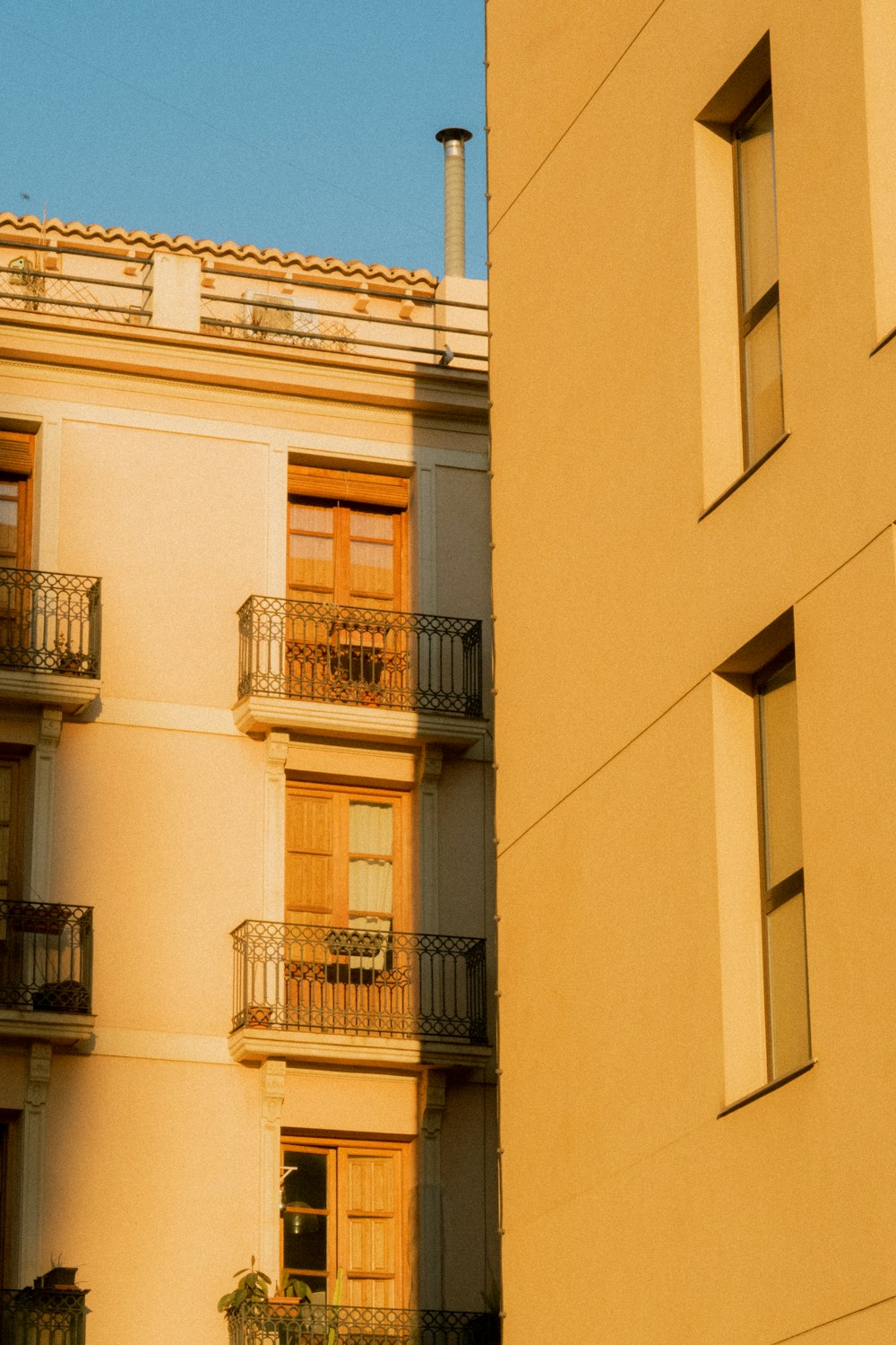 a building with balconies and a clock on the side of it