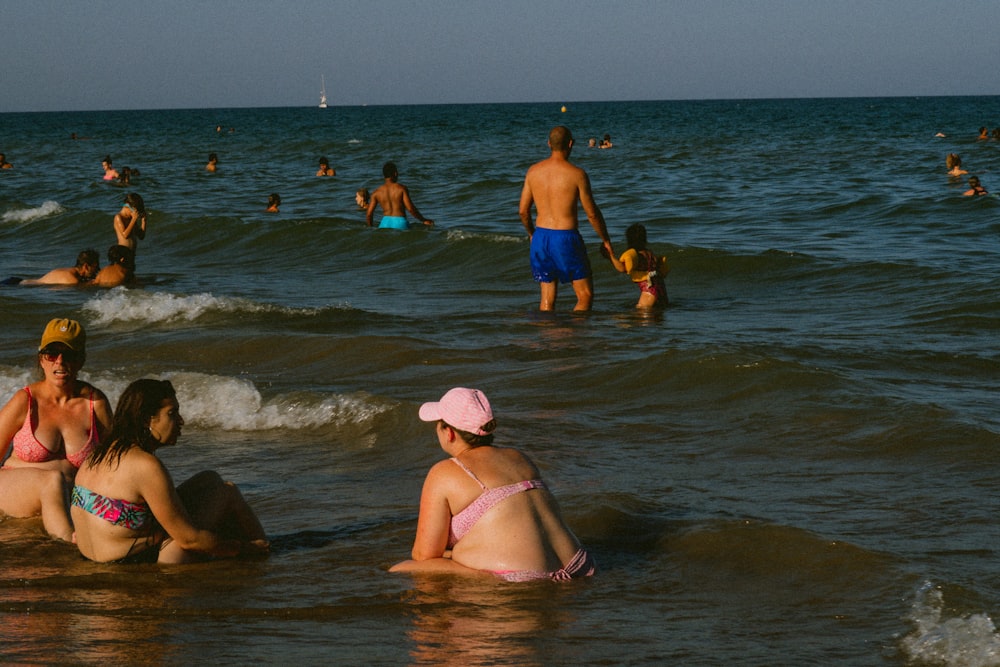 a group of people in the water at the beach