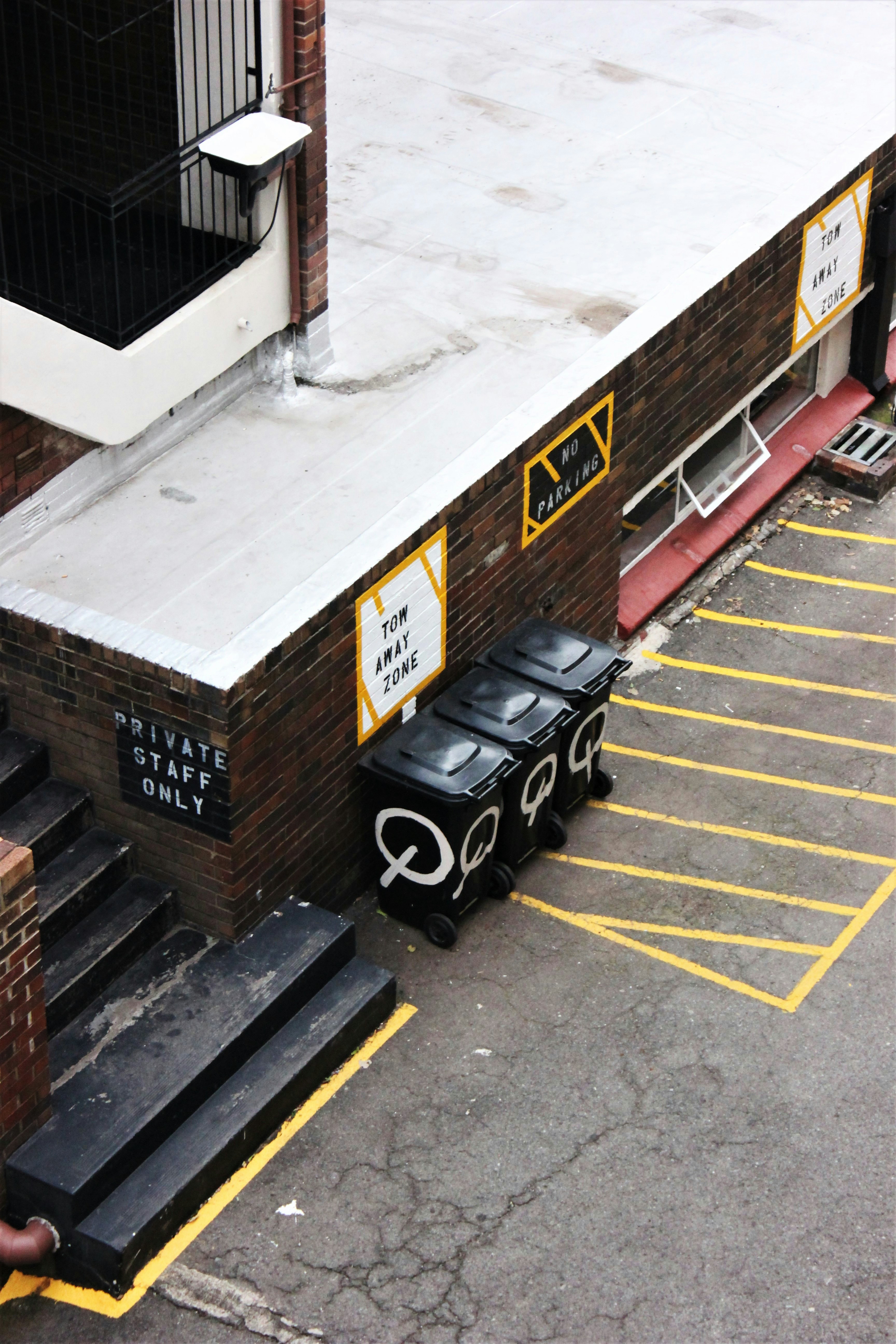 a parking lot with a bunch of black trash cans