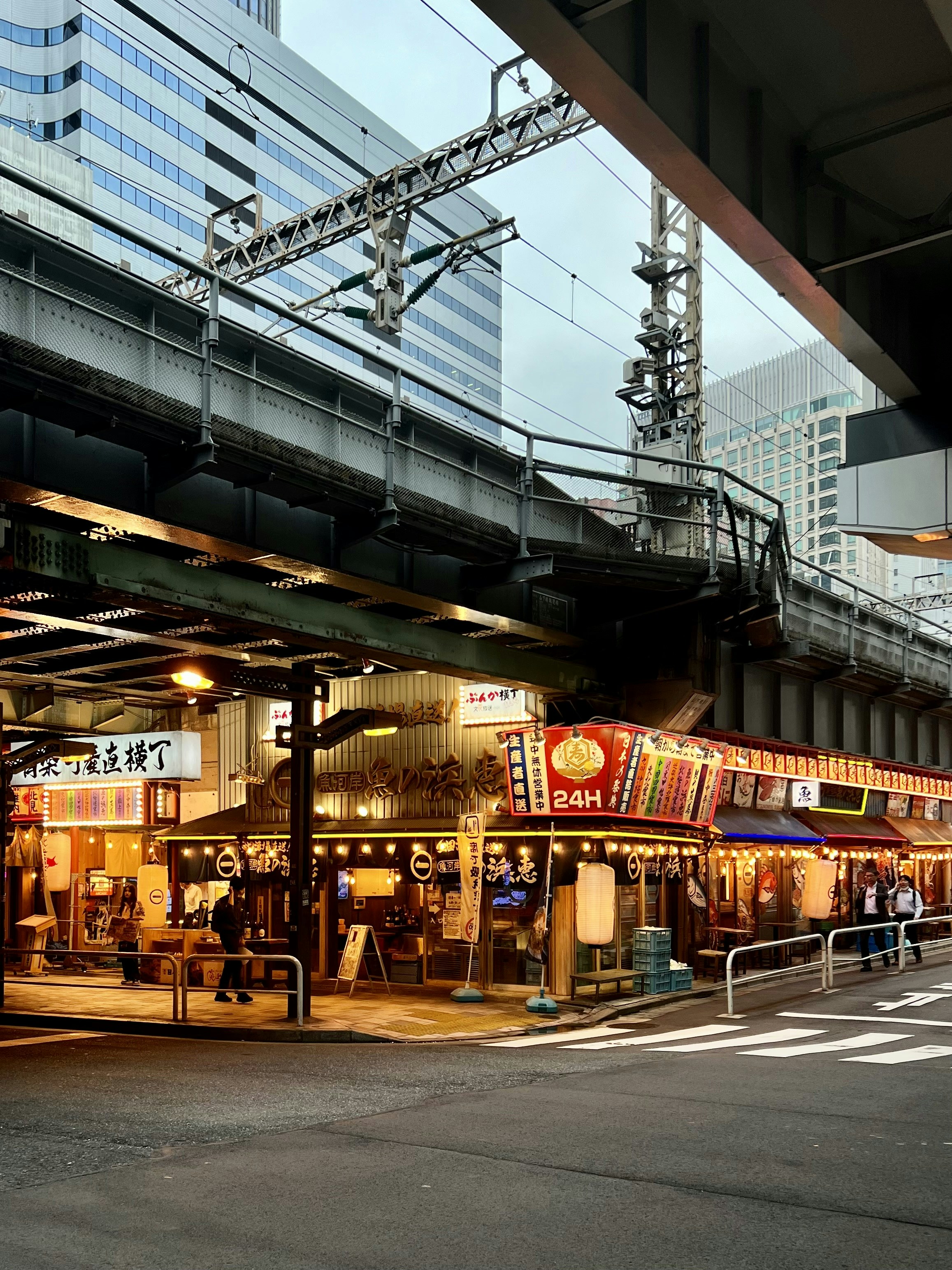 a city street with a train crossing over it