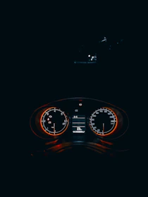 A sleek speedometer graphic glowing in red and black, symbolizing rapid website performance.