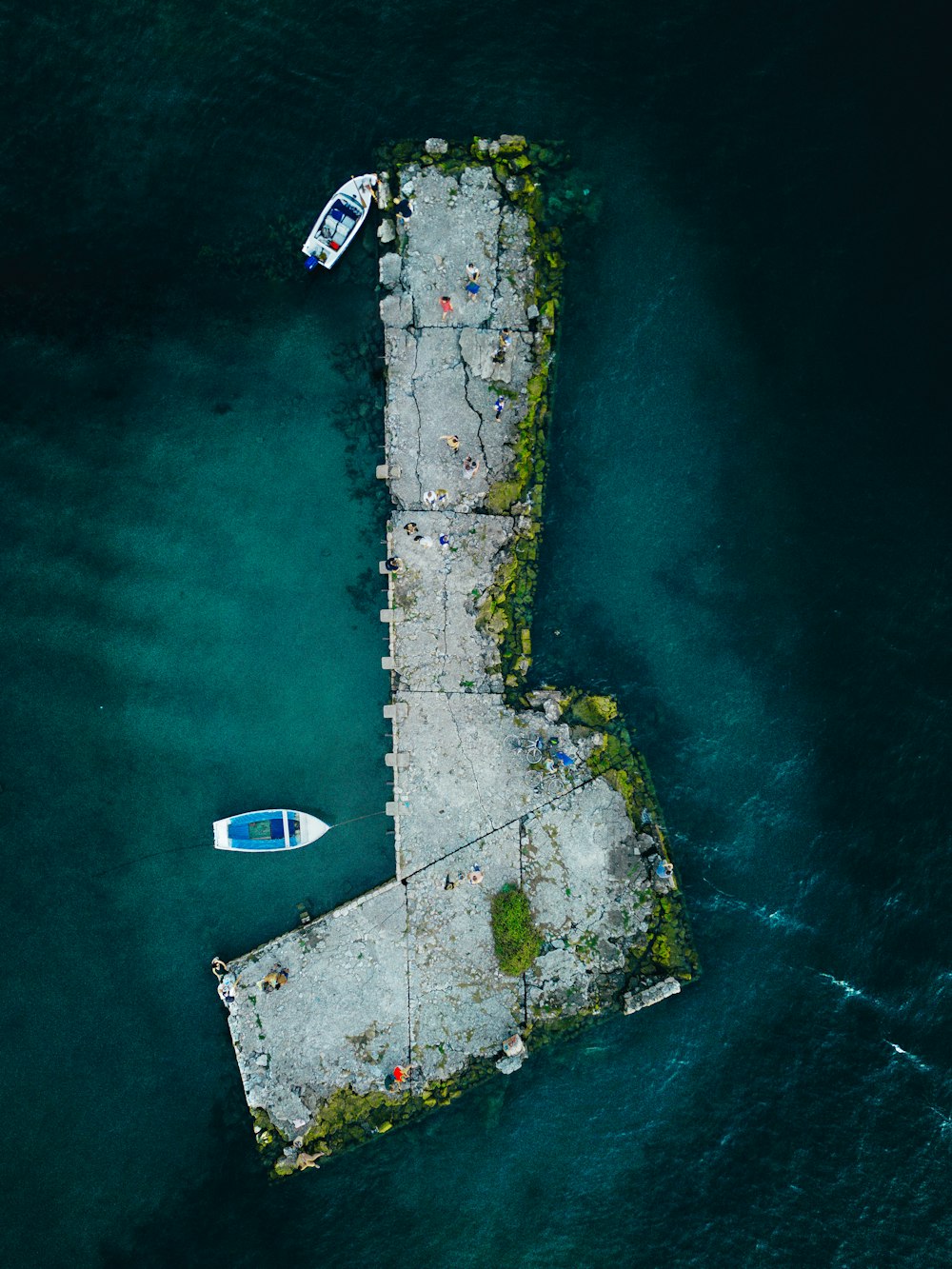an aerial view of a pier with two boats