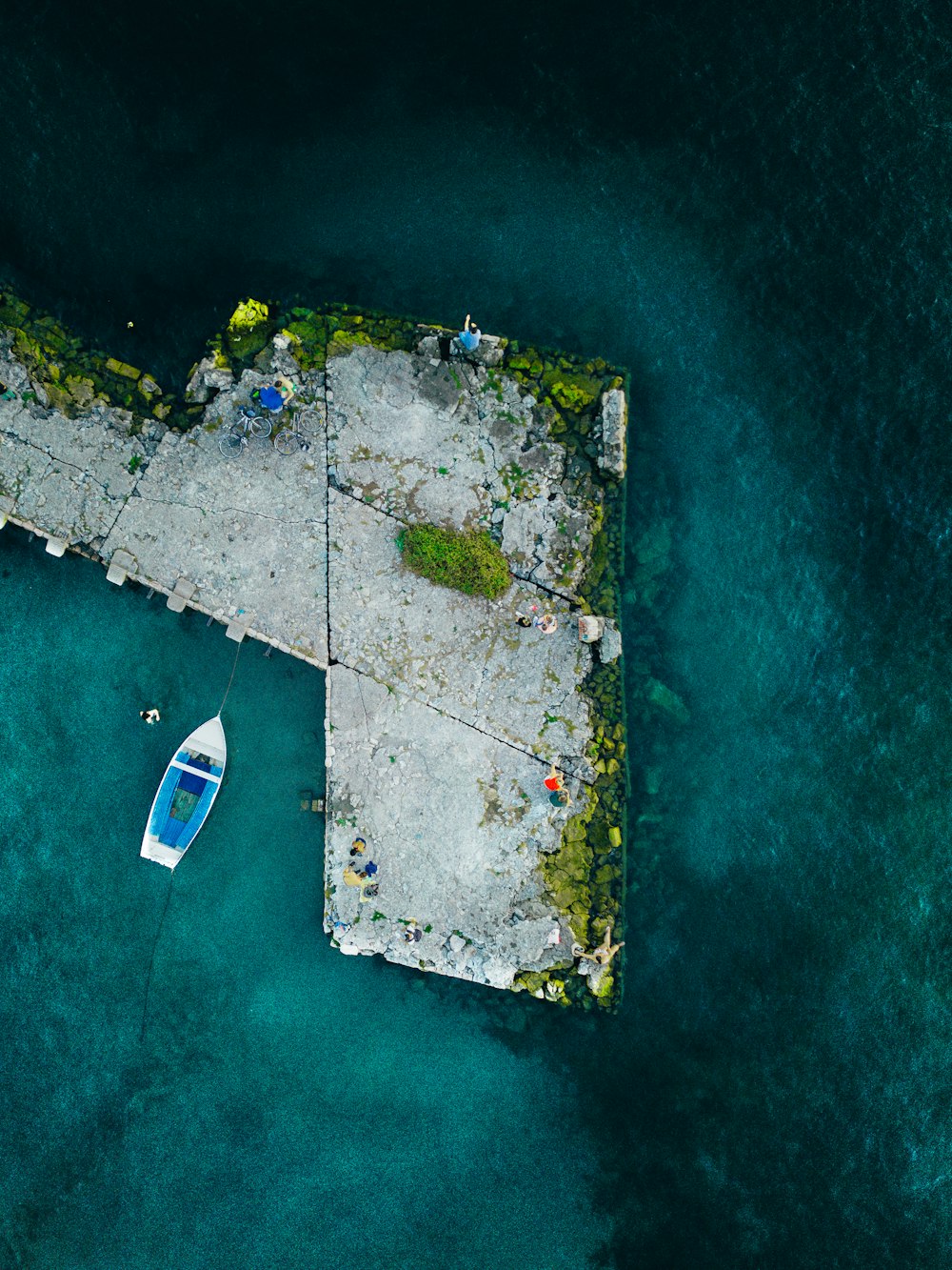 an aerial view of a dock with a boat in the water