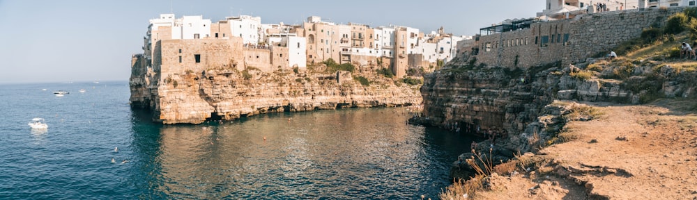 a body of water surrounded by buildings and cliffs