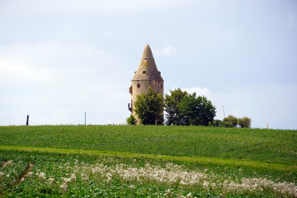 a tall tower sitting on top of a lush green hillside