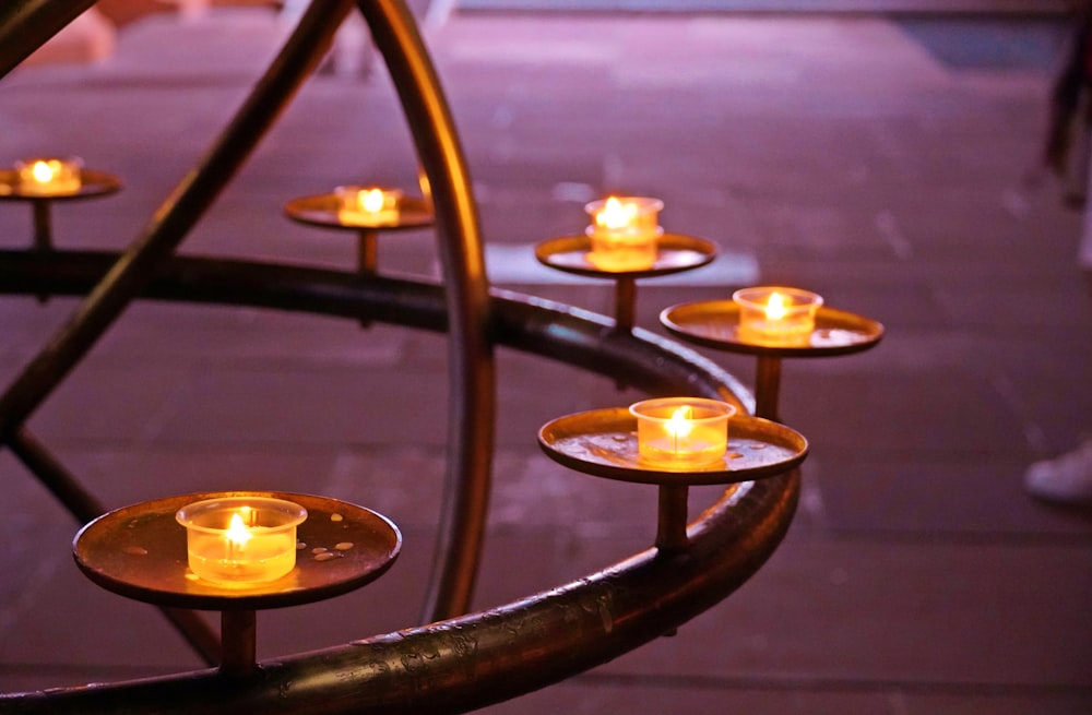 a group of lit candles sitting on top of a metal table