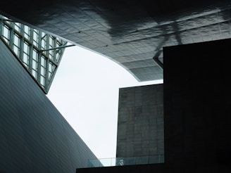 A geometric architectural scene with angular structures and modern design, where overlapping panels and open spaces create unique shadows and textures.