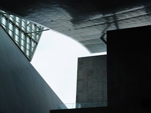A geometric architectural scene with angular structures and modern design, where overlapping panels and open spaces create unique shadows and textures.