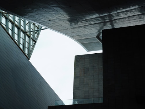A geometric architectural scene with angular structures and modern design, where overlapping panels and open spaces create unique shadows and textures.