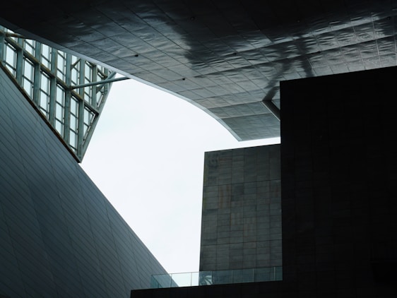 A geometric architectural scene with angular structures and modern design, where overlapping panels and open spaces create unique shadows and textures.