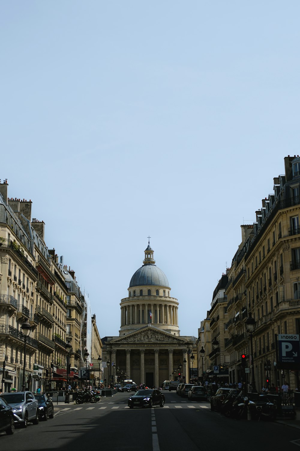 a city street with a domed building in the background