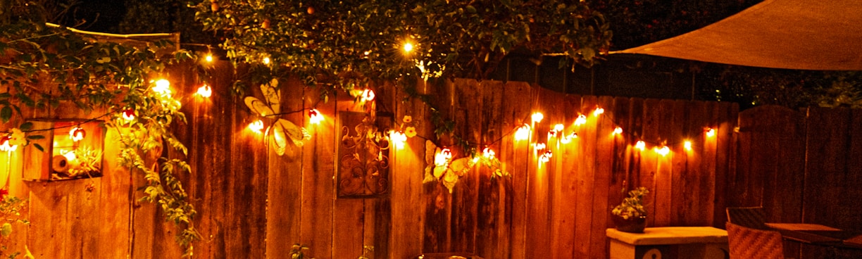 a wooden fence with lights hanging from it