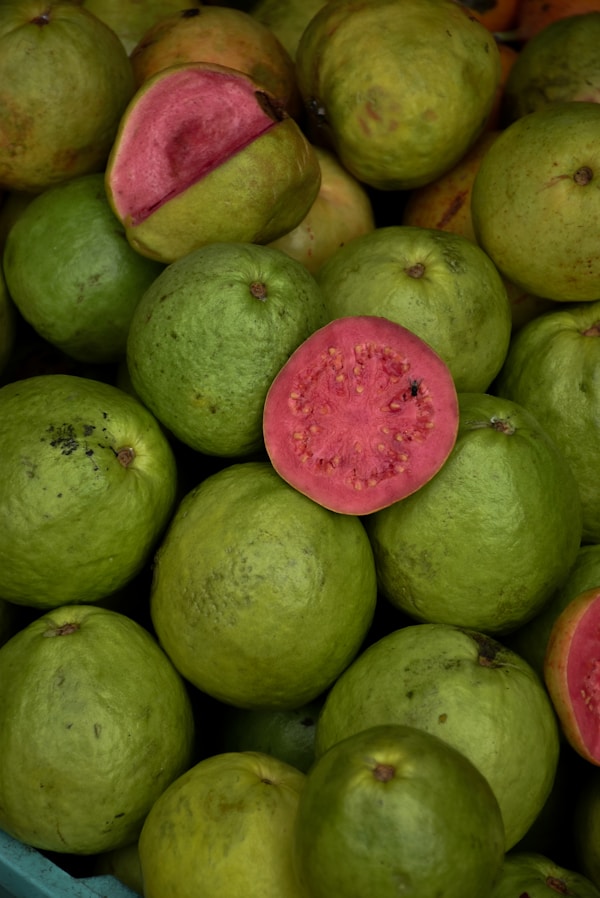 A pile of green and red fruit sitting on top of each other