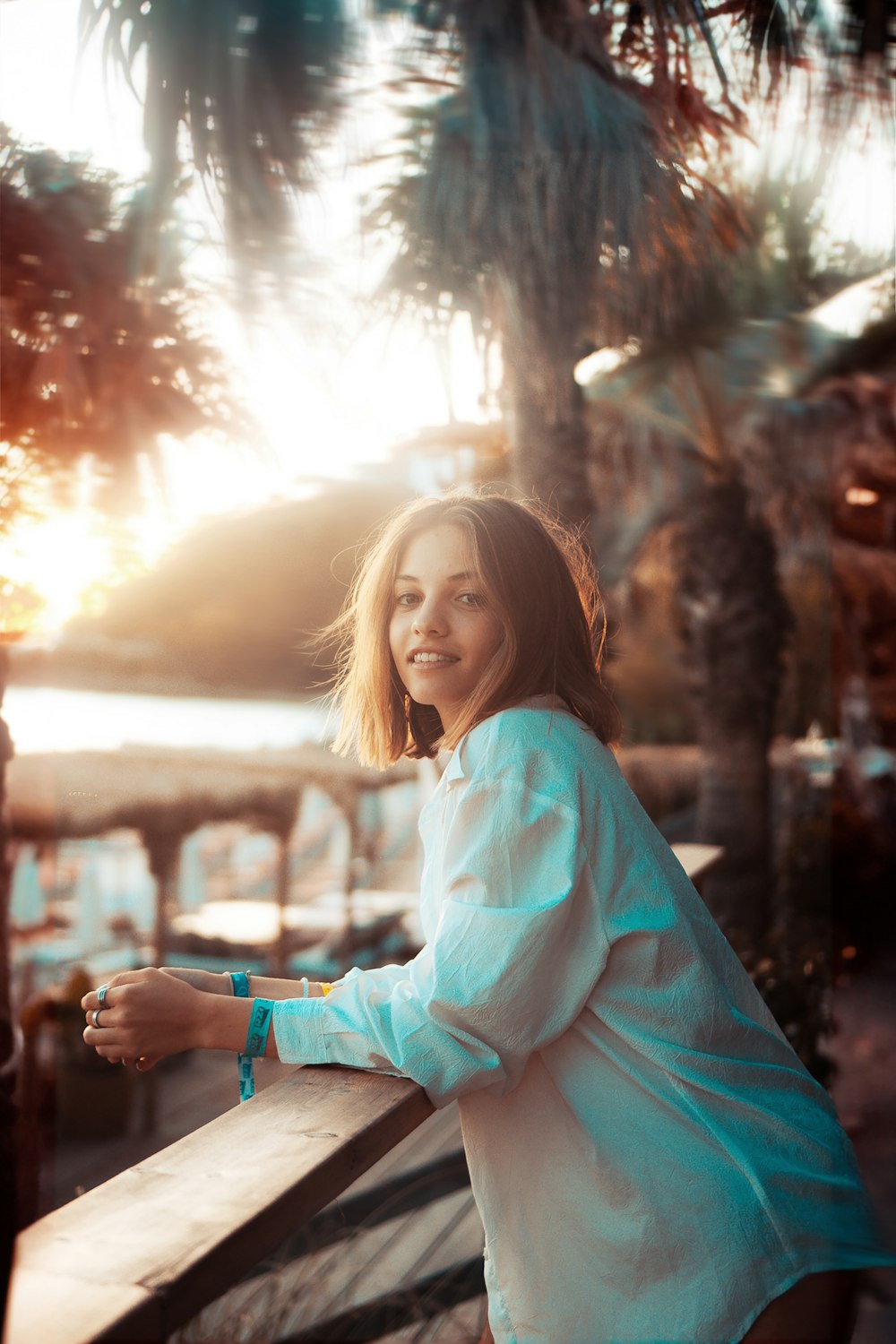 a woman standing next to a wooden fence