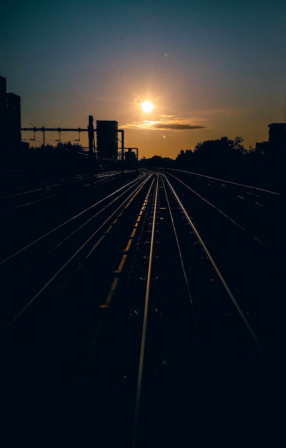 the sun is setting over a train track