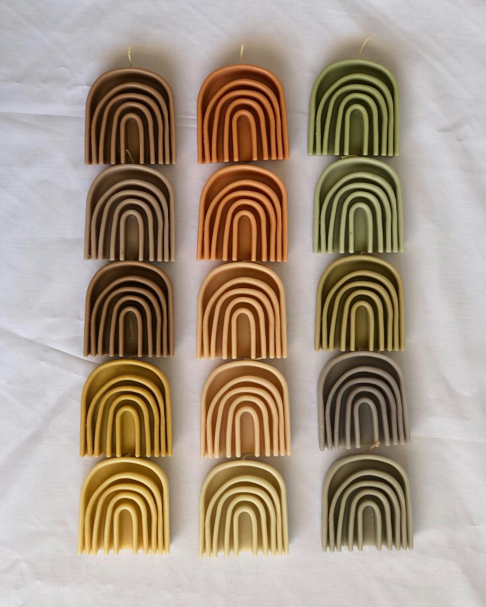 a set of nine rainbow candles sitting on top of a white sheet