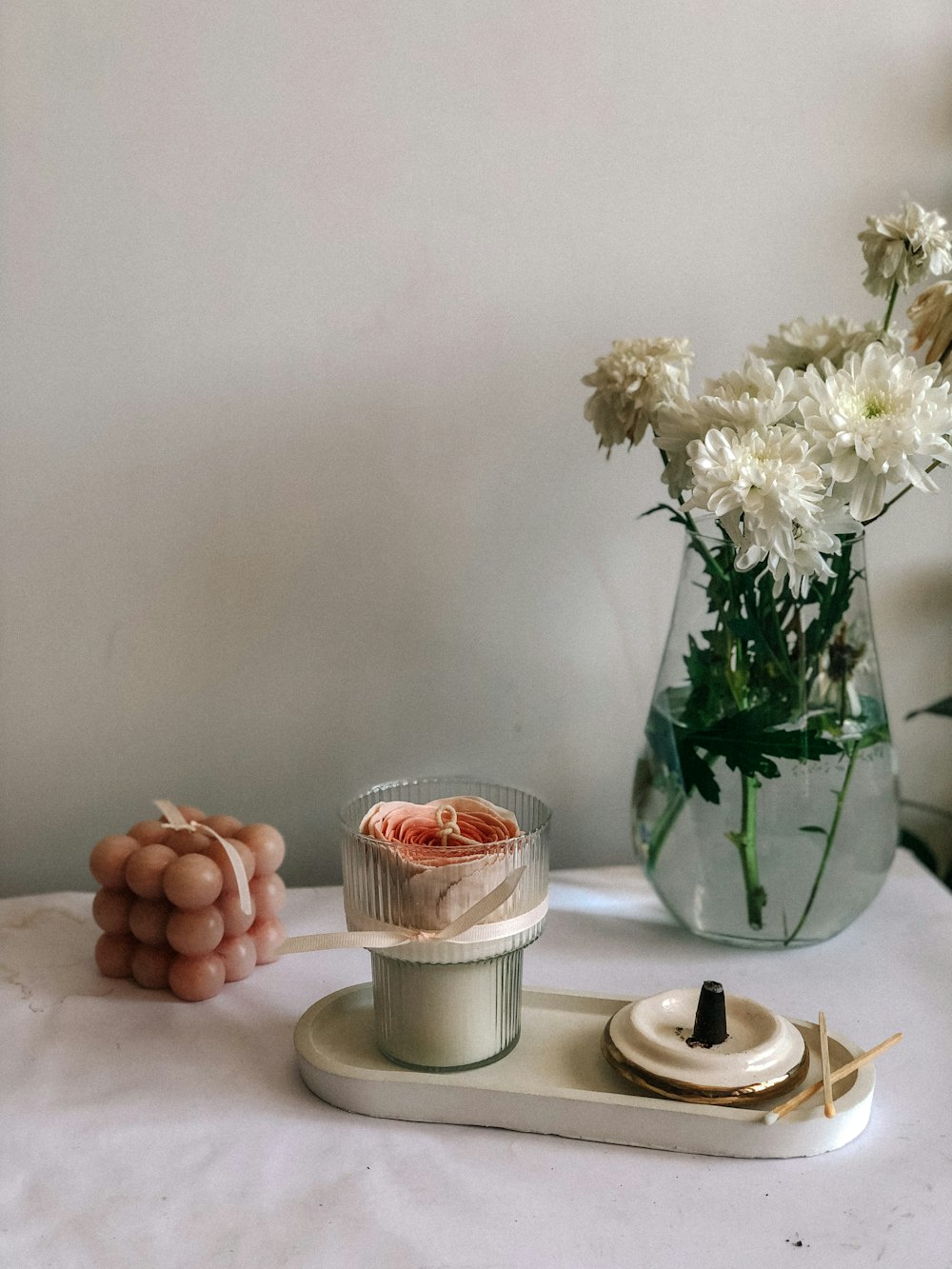 a table with a vase of flowers and a candle holder