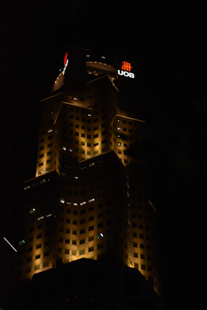 Nighttime exterior of a luxury building illuminated with subtle golden lighting highlighting architectural details.