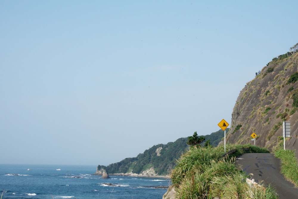 a view of the ocean from the side of a road