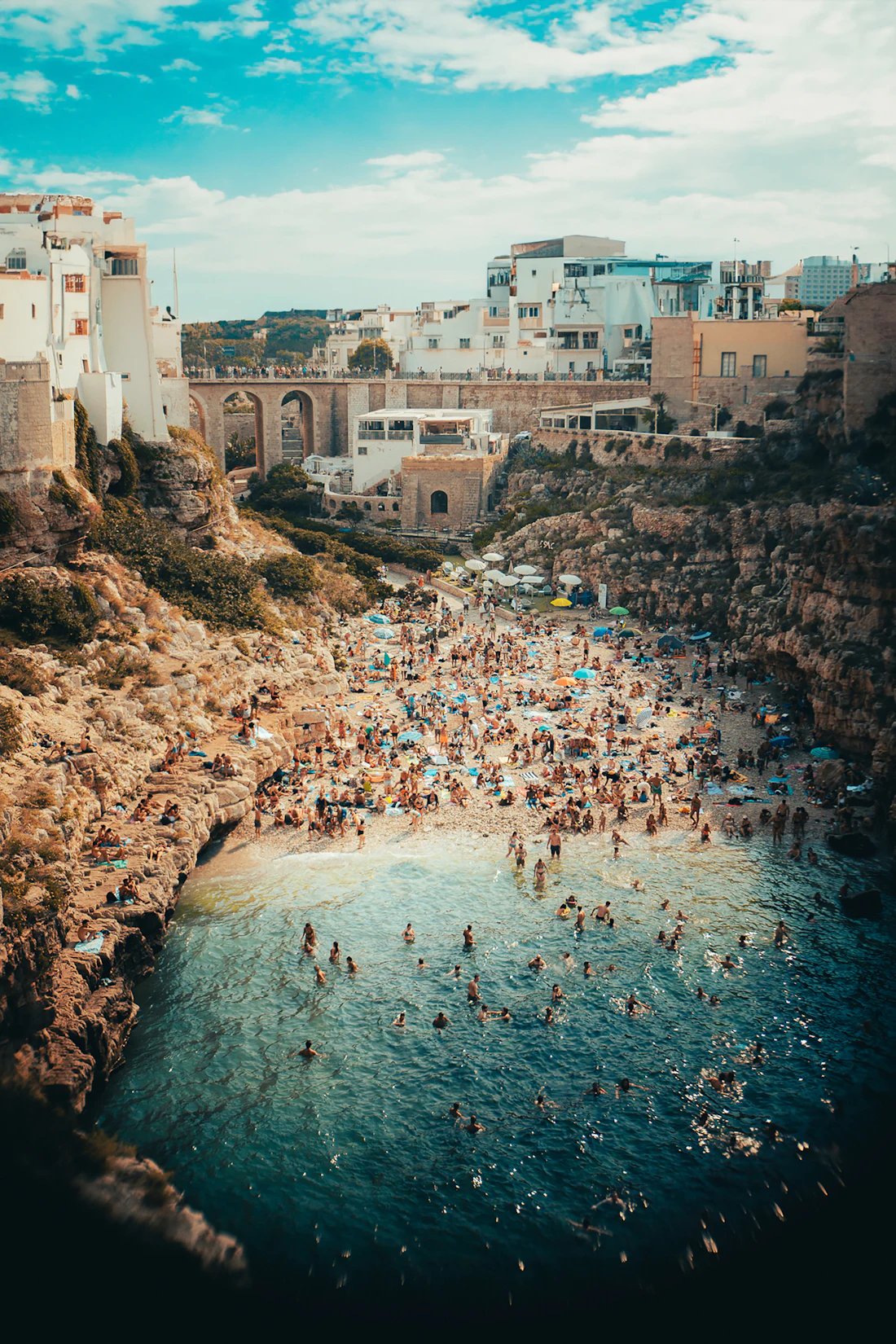 Swimmers in clear water between limestone walls