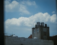 A technician cleaning a water tank on a rooftop under clear sky.