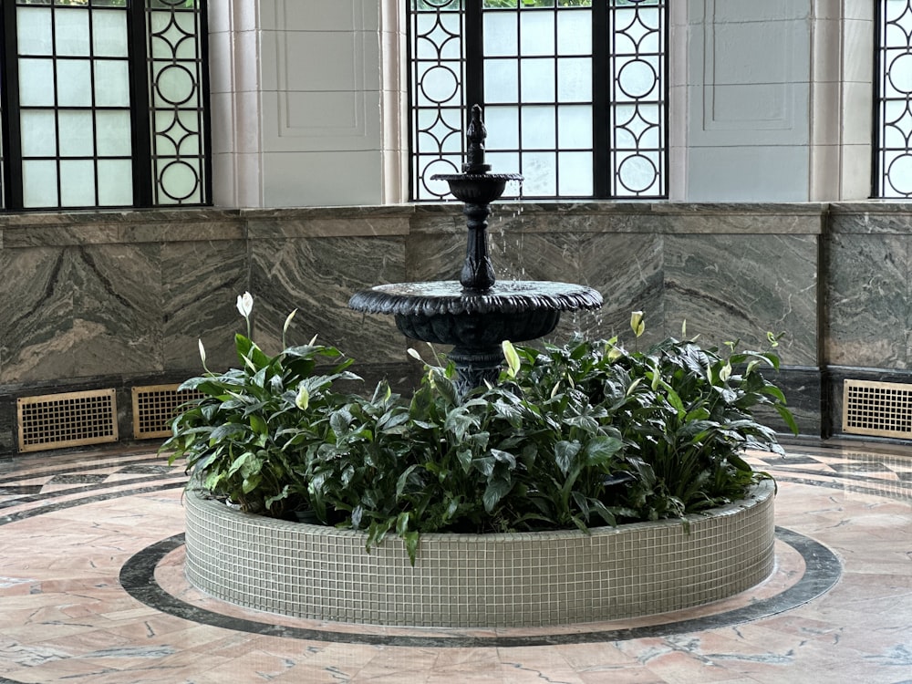 a fountain with a planter in the middle of it