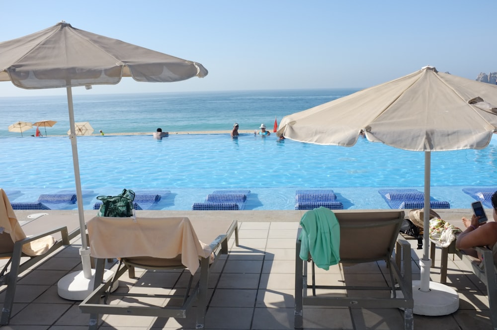 a group of people sitting around a swimming pool