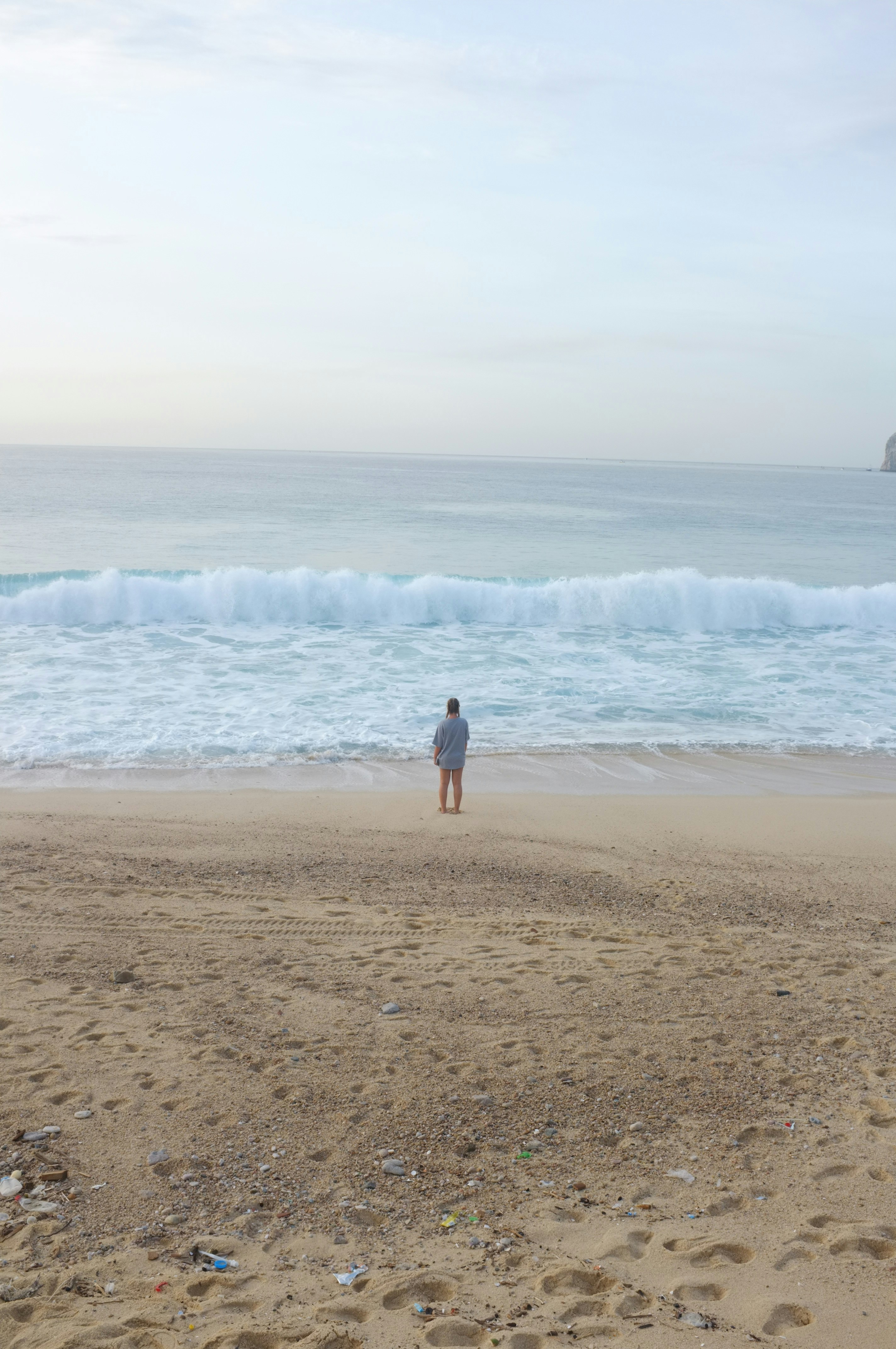 a person standing on a beach next to the ocean