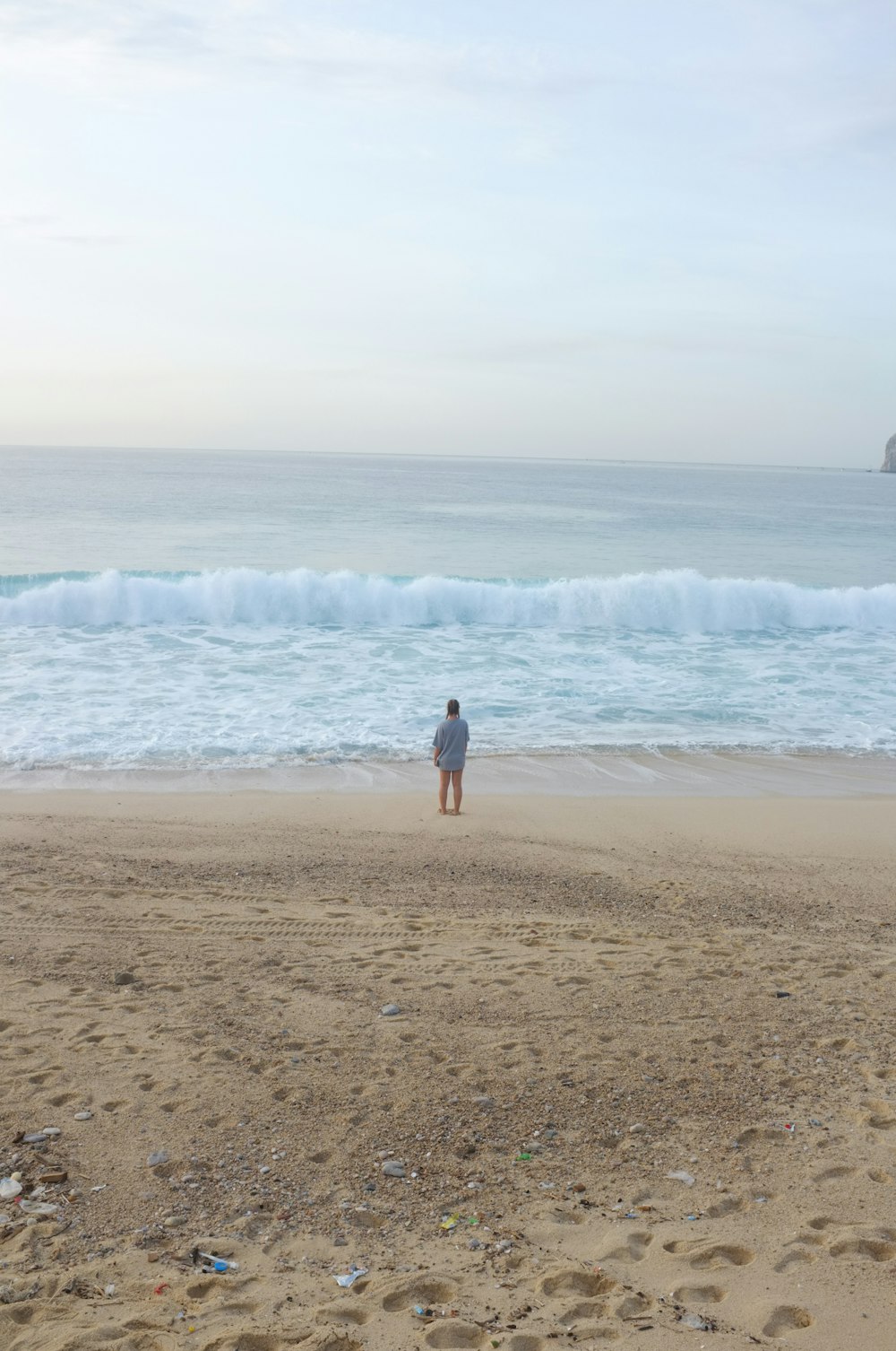 a person standing on a beach next to the ocean