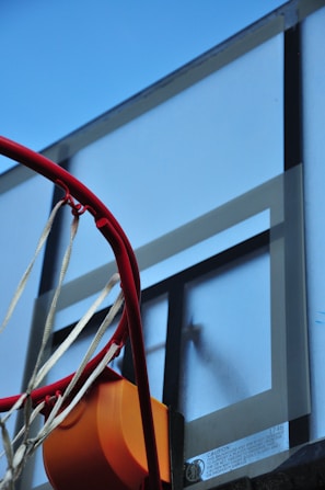 Close-up shot of a newly installed basketball hoop on a concrete court with bright markings