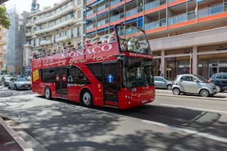 a red double decker bus driving down a street