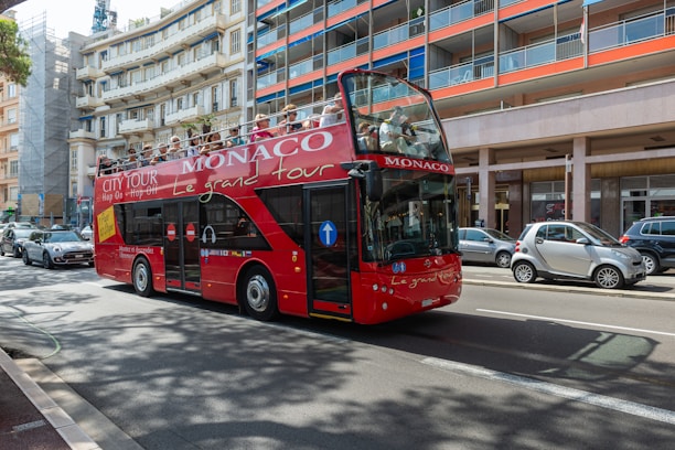 a red double decker bus driving down a street