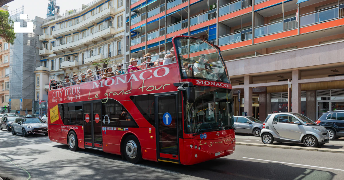 A red double decker bus driving down a street photo – Free Car Image on ...