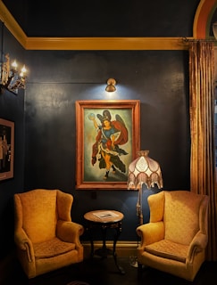 A cozy corner showcasing hand-painted furniture with maroon and creme accents under soft lighting.