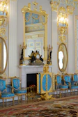 Spacious elegant living room with blue and gold decor reflecting luxury
