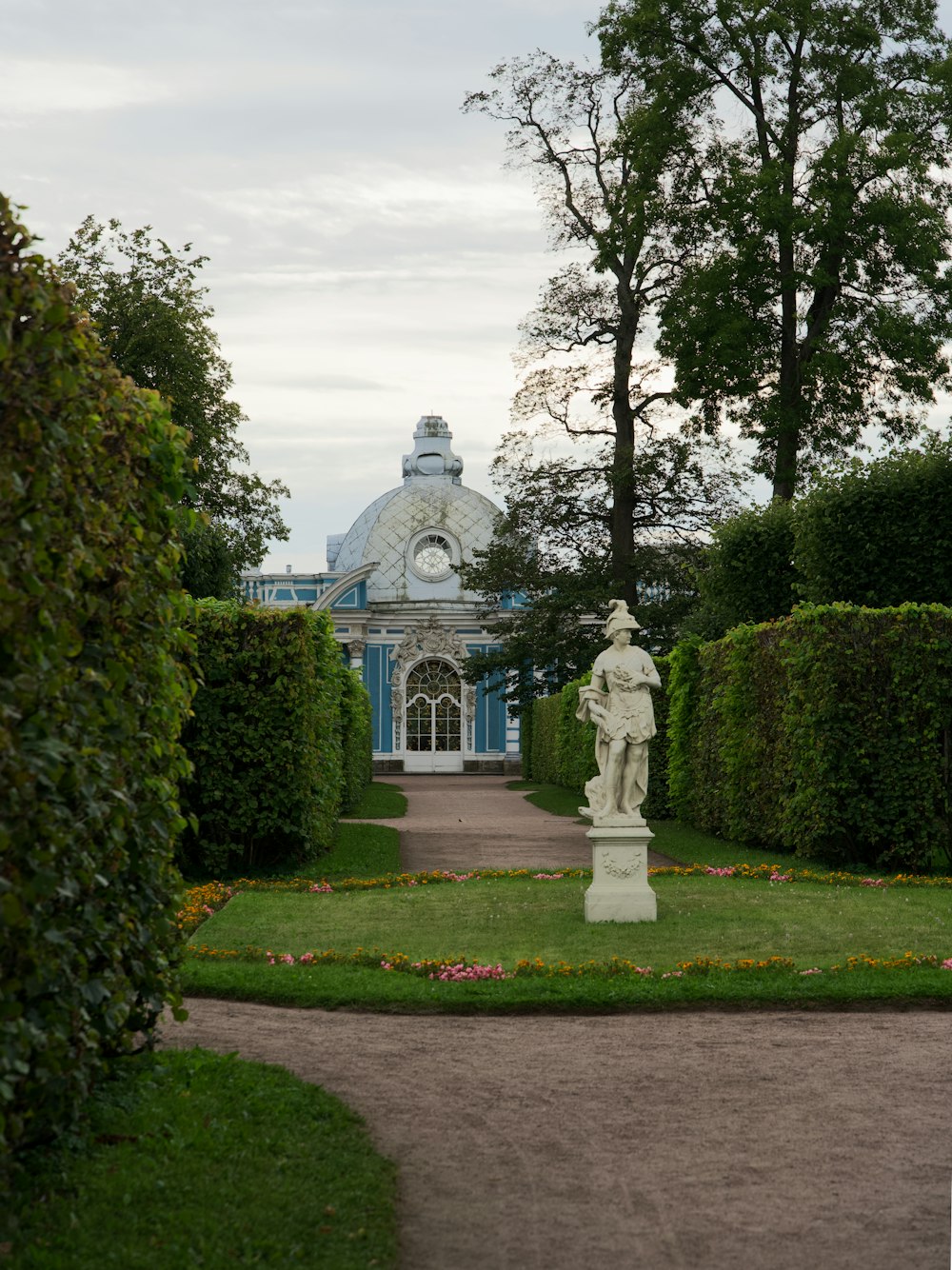 a garden with a statue in the middle of it