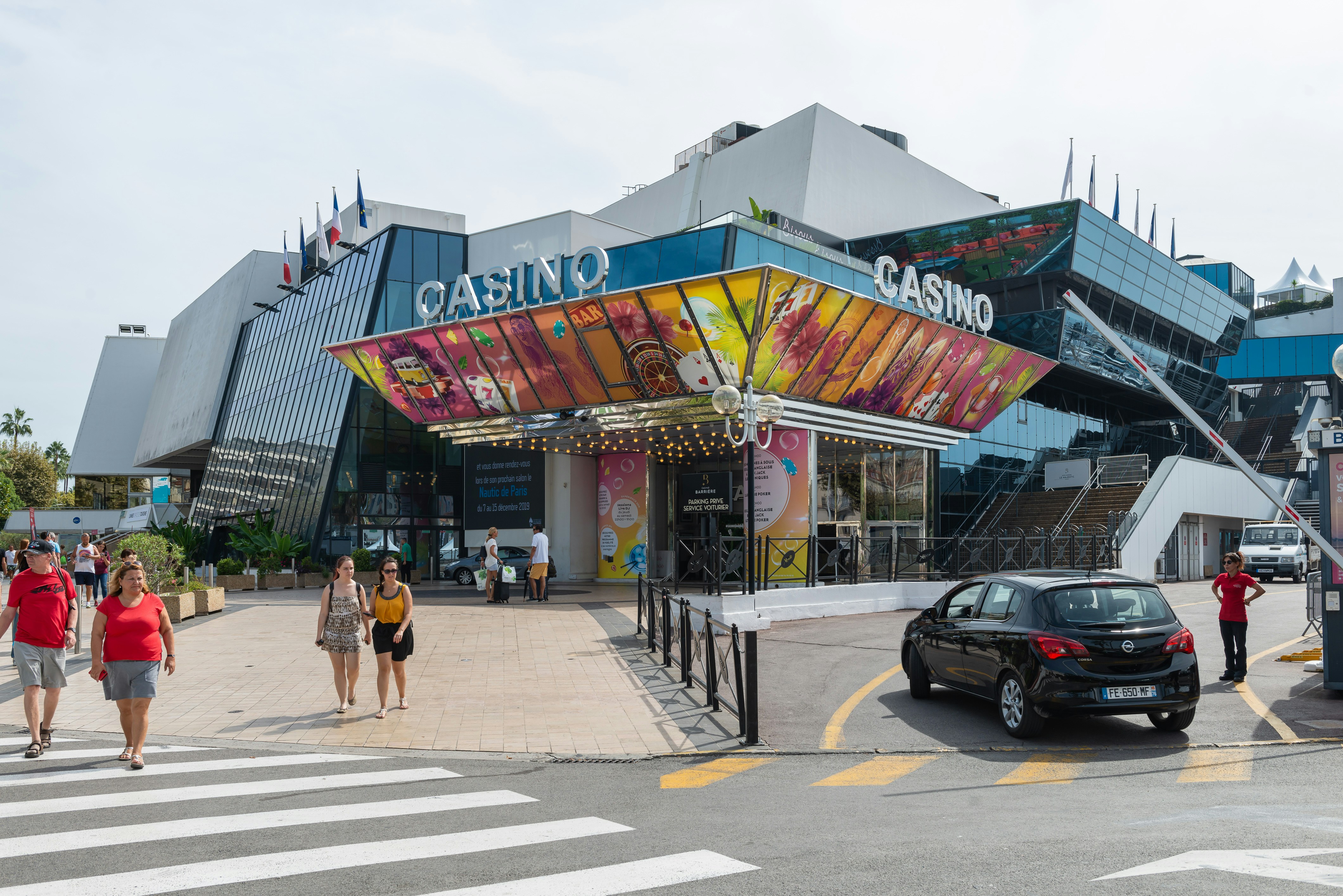 a group of people crossing a street in front of a casino