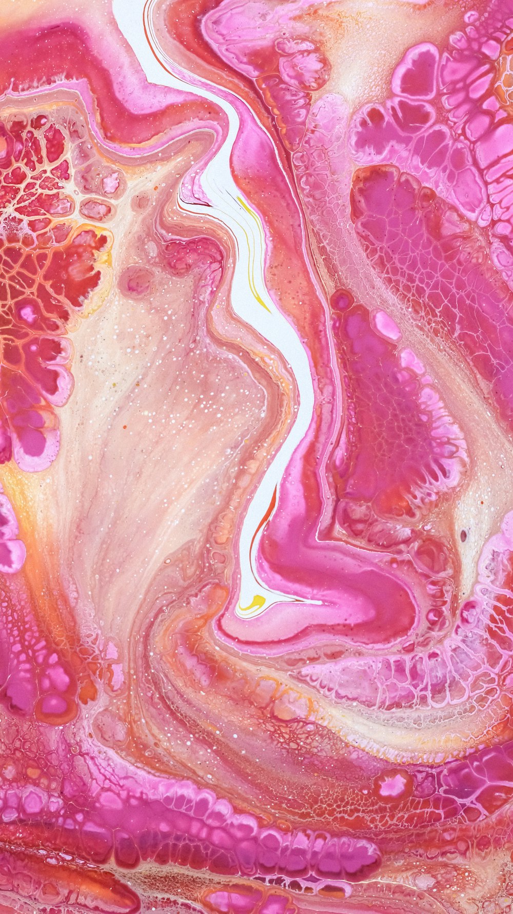 a close up of a pink and yellow fluid painting