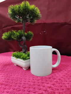 A cozy ceramic mug with pastel pink glaze resting on a wooden table beside a small succulent plant.